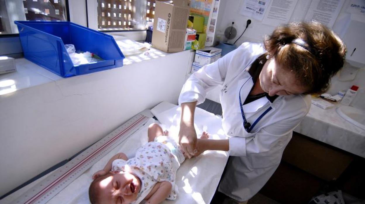 Un bebé recibiendo una vacuna en una consulta sanitaria