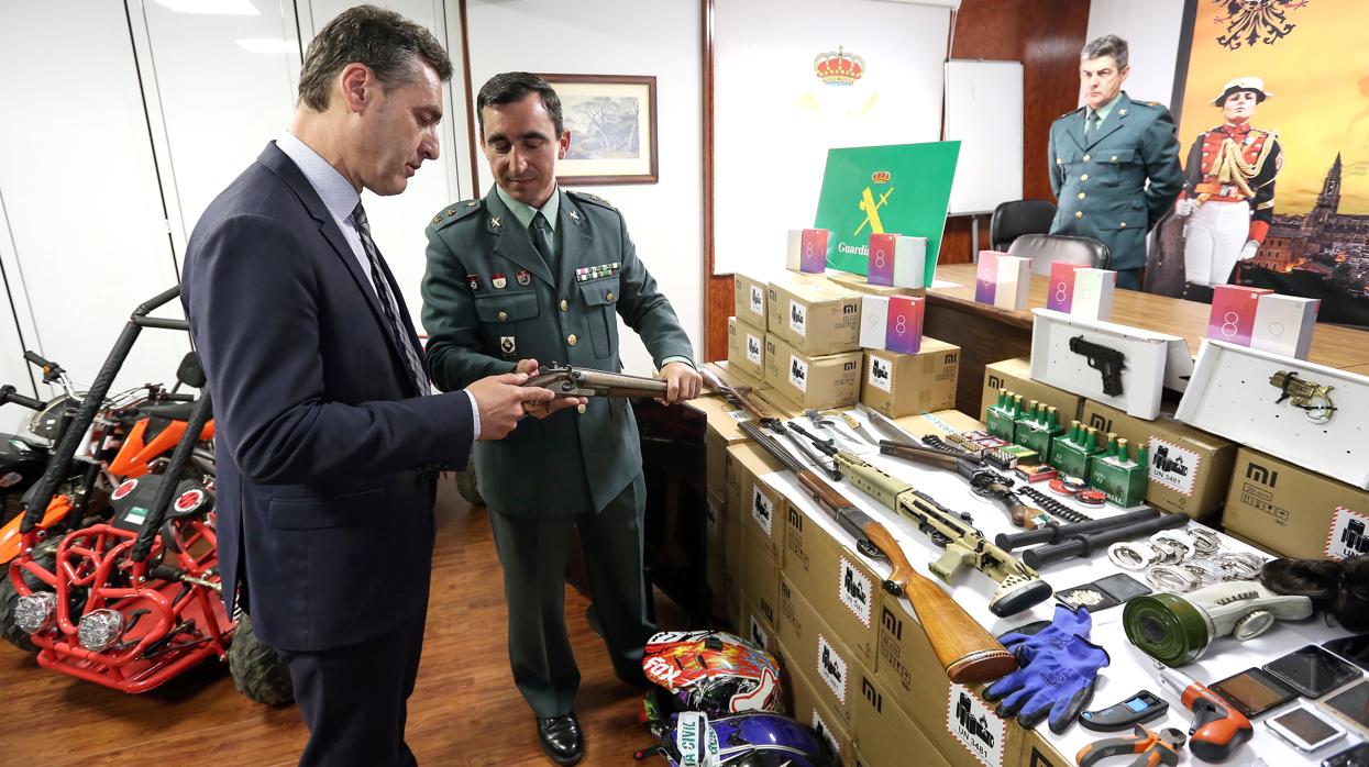 El teniente coronel José María Gil muestra al delegado del Gobierno una escopeta recortada decomisada a uno de los grupos criminales