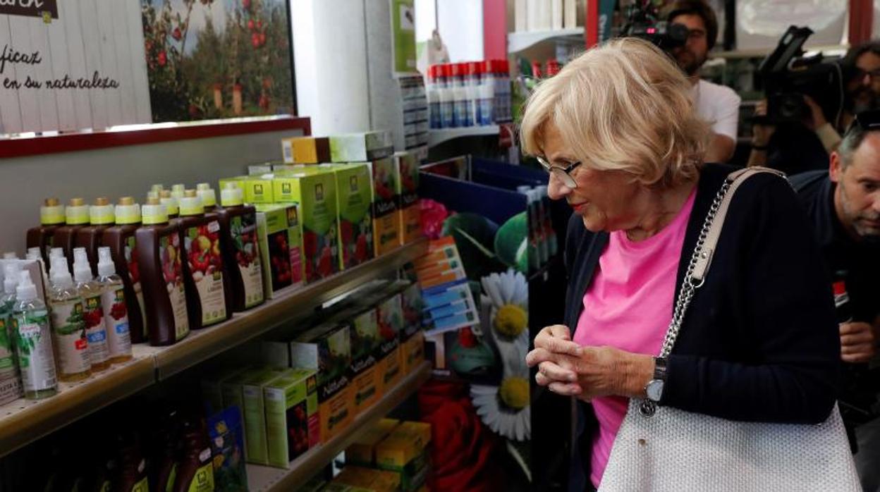 La alcaldesa de la capital, Manuela Carmena, en una tienda de jardinería durante el día de reflexión