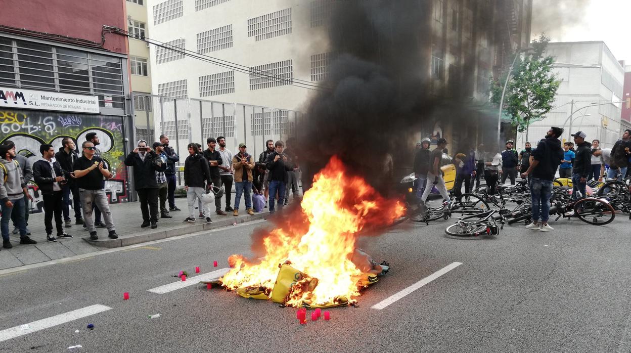 Repartidores de Glovo queman mochilas en señal de protesta