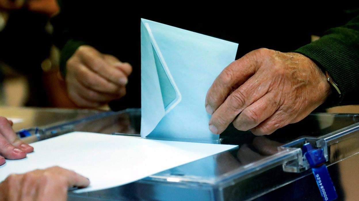 Un ciudadano deposita su voto en un centro electoral en el centro de Madrid