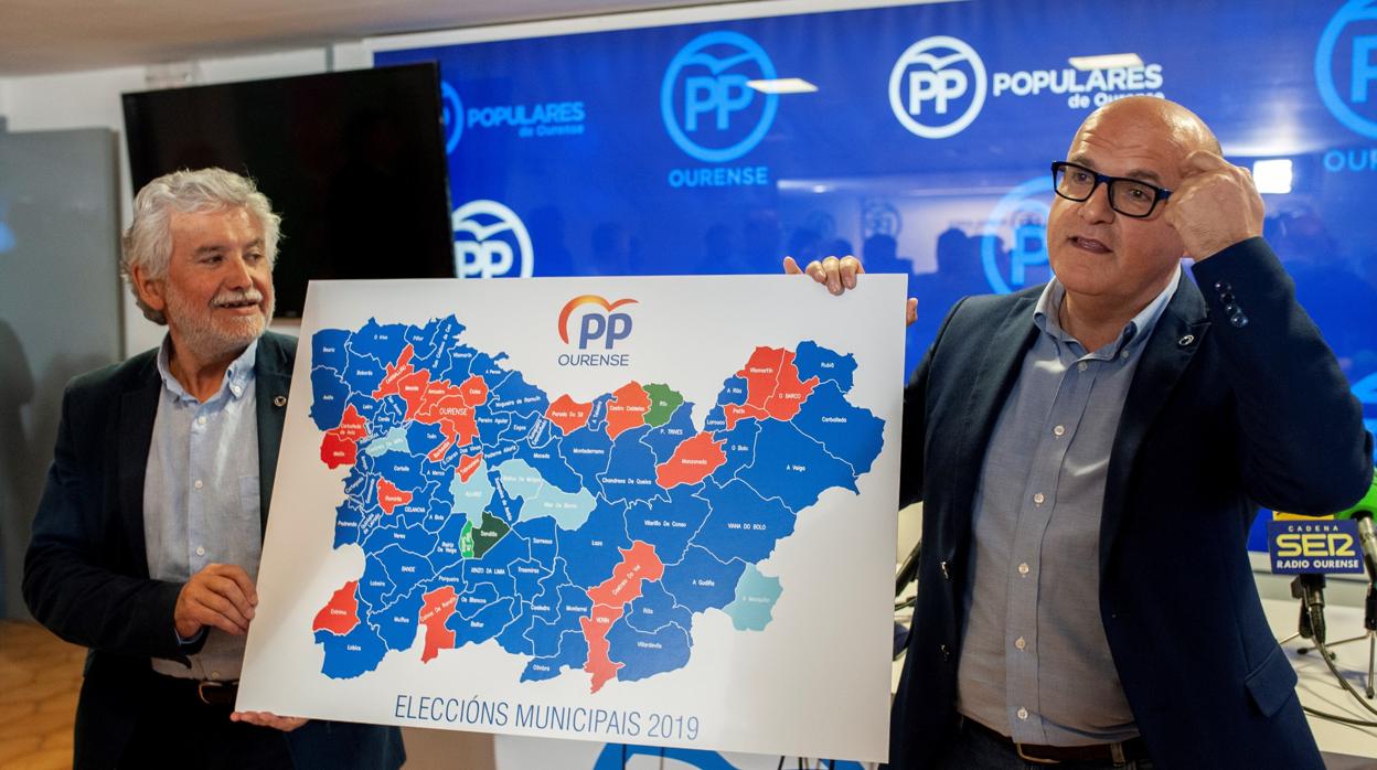 Manuel Baltar y Rosendo Fernández muestran el mapa de la provincia con los concellos con victoria popular coloreados en azul