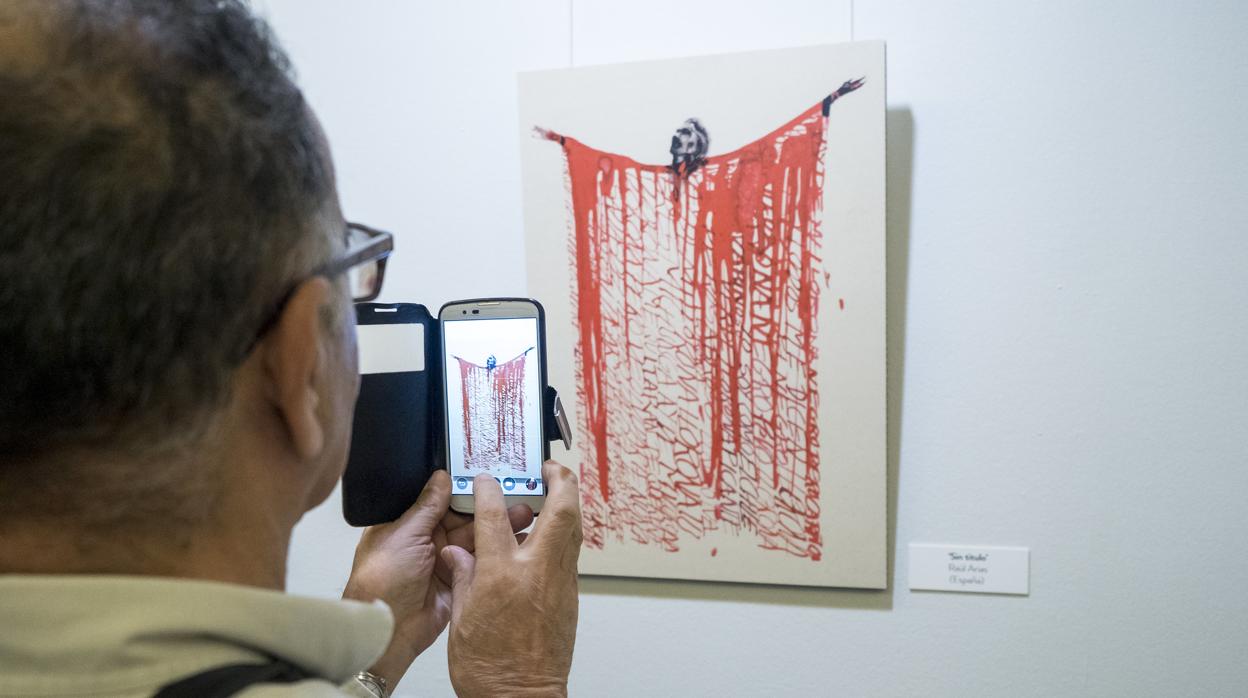 Un visitante fotografía una obra de Raúl Arias sobre Chavela Vargas, en Casa de América