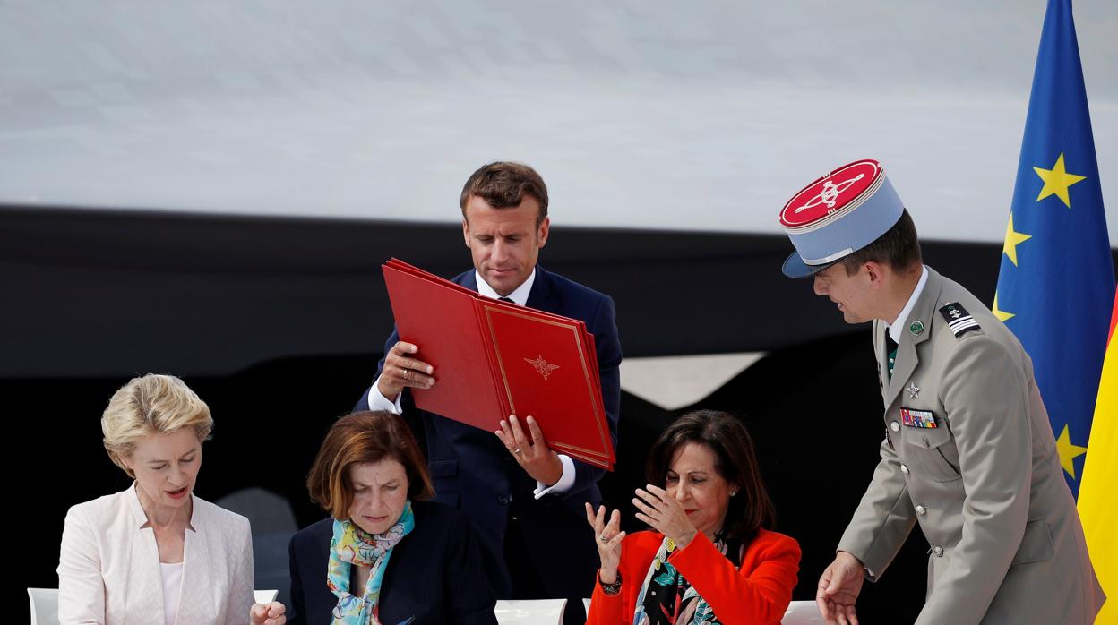 La ministra Robles recibe el memorando de manos de Macron; al lado, sus colegas francesa y alemana