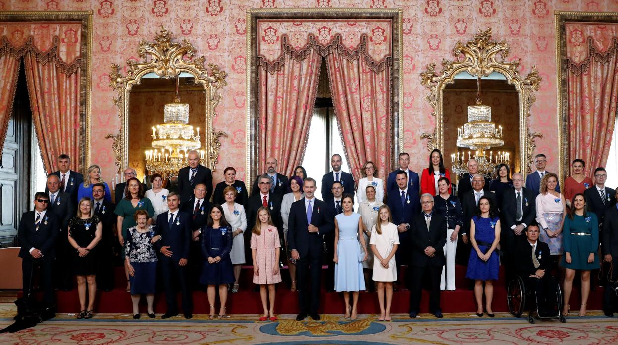 Los Reyes, la Princesa de Asturias y la Infanta Sofía, con los 41 ciudadanos condecorados con la Órden del Mérito Civill, ayer en Palacio Real