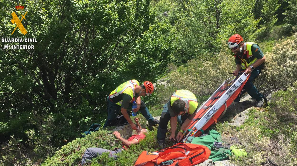 Tres agentes atienden al senderista en el lugar donde lo encontraron