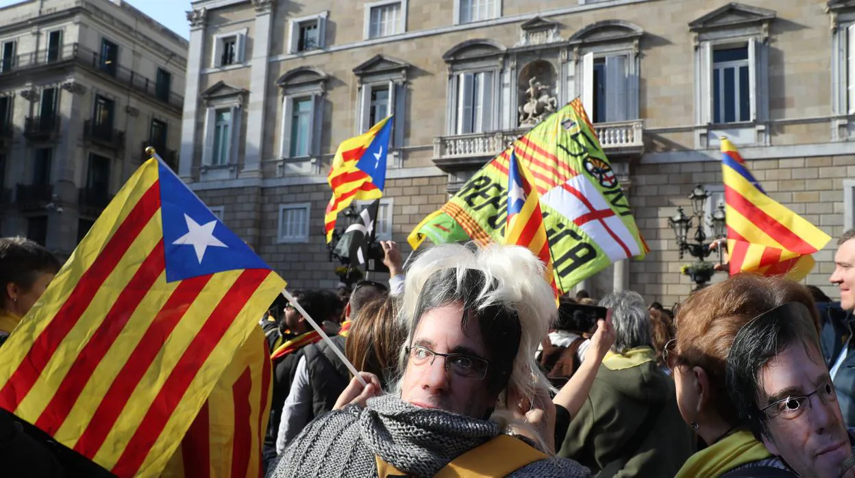 Una mujer con una careta de Carles Puigdemont ante el Palau de la Generalitat
