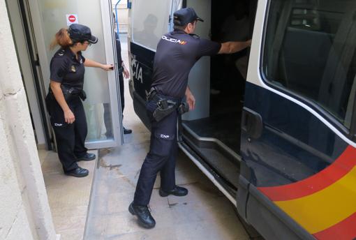 Imagen de dos agentes de la Policía Nacional sacando a un detenido del furgón policial