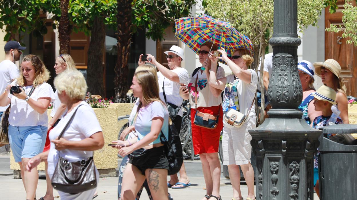 Imagen de archivo de unos turistas en Valencia protegiéndose del sol