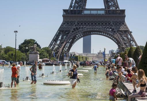 Imagen de archivo de una multitud de turistas refrescándose en la fuente de los jardines del Trocadero