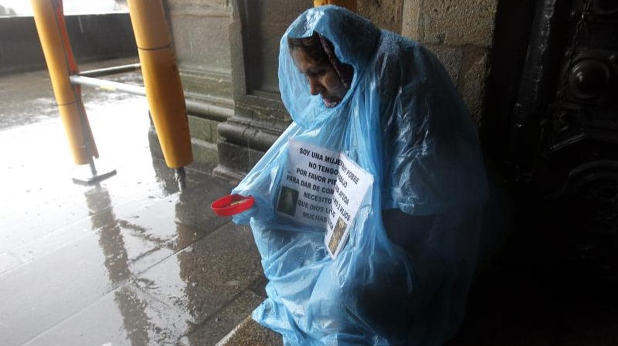Una mujer pidiendo limosna en la zona vieja de Santiago de Compostela