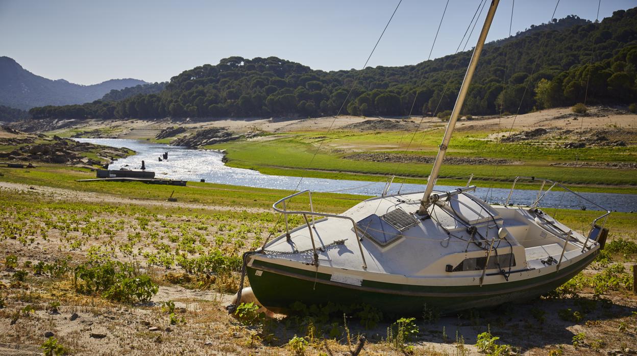 Un barco encallado junto al río Alberche, casi seco, en la cola del pantano de San Juan