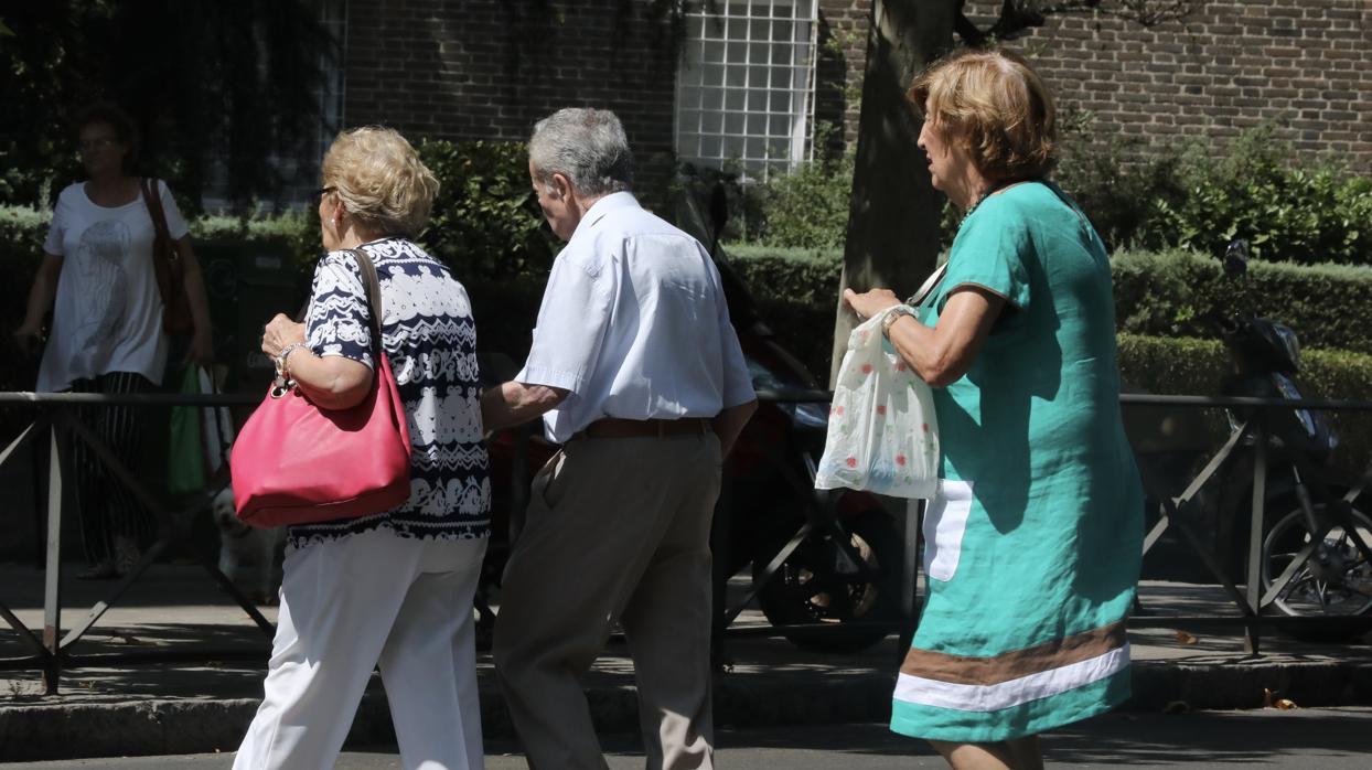 Imagen de archivo de tres personas mayores cruzando una calle