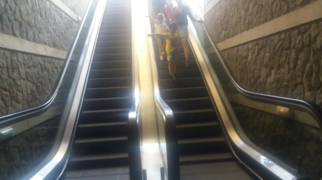 Unos niños bajan los peldaños de un tramo de escalera averiado