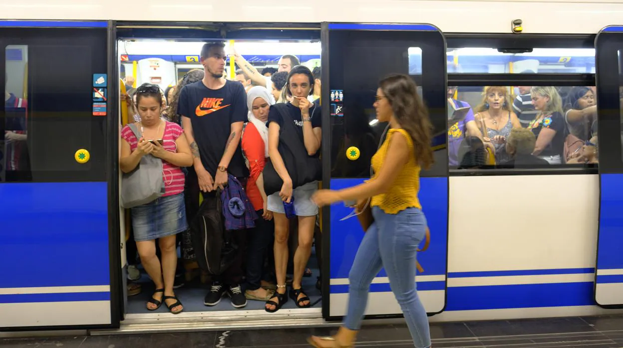 Viajeros tratando de hacerse hueco en un vagón atestado de gente