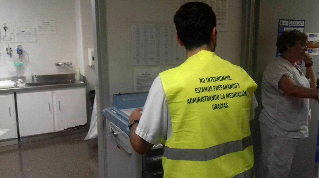 Un enfermero con el chaleco reflectante amarillo y el mensaje de advertencia a pacientes y familiares