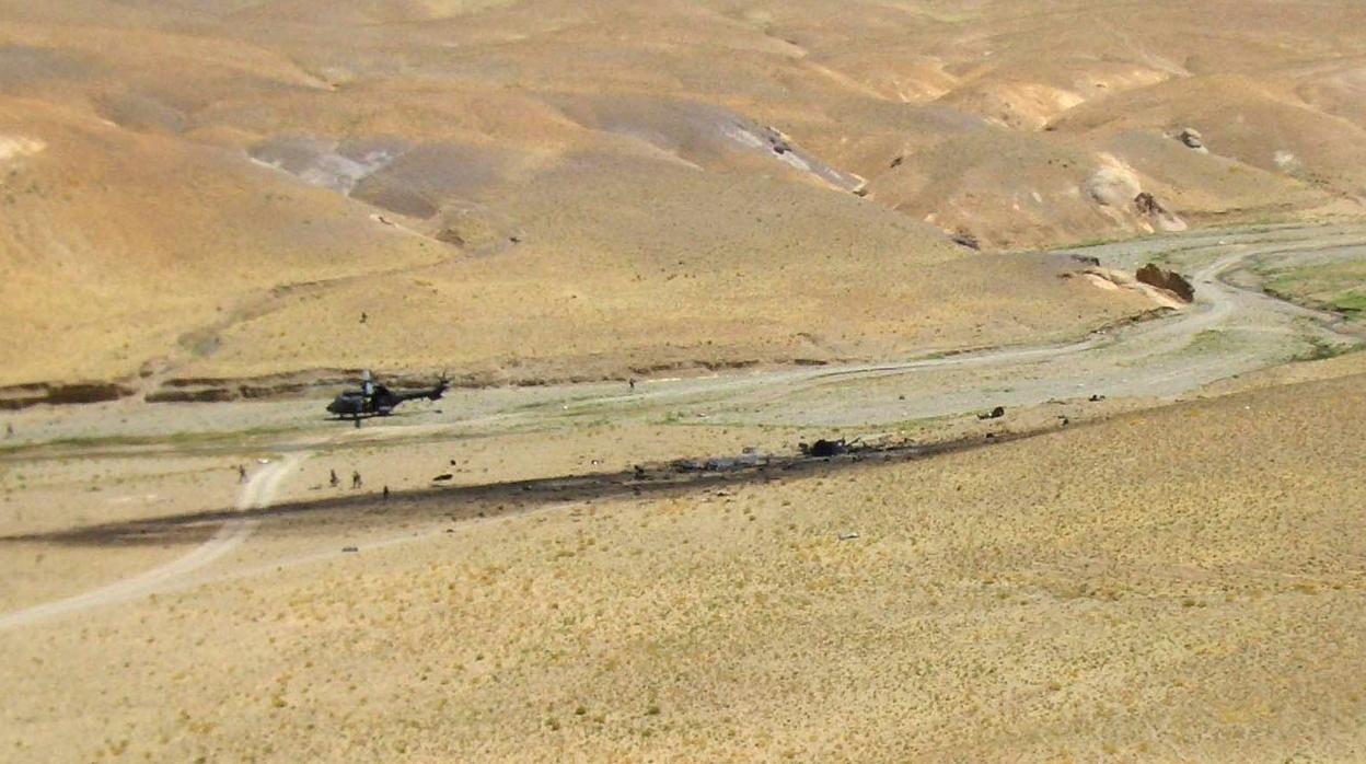 Vista de los restos del helicóptero "Cougar", que se estrelló en Afganistán cuando participaba en una operación de integración de las Fuerzas Armadas españolas, en el que fallecieron diecisiete militares españoles. A la izquierda el helicóptero medicalizado que acudió al lugar de los hechos