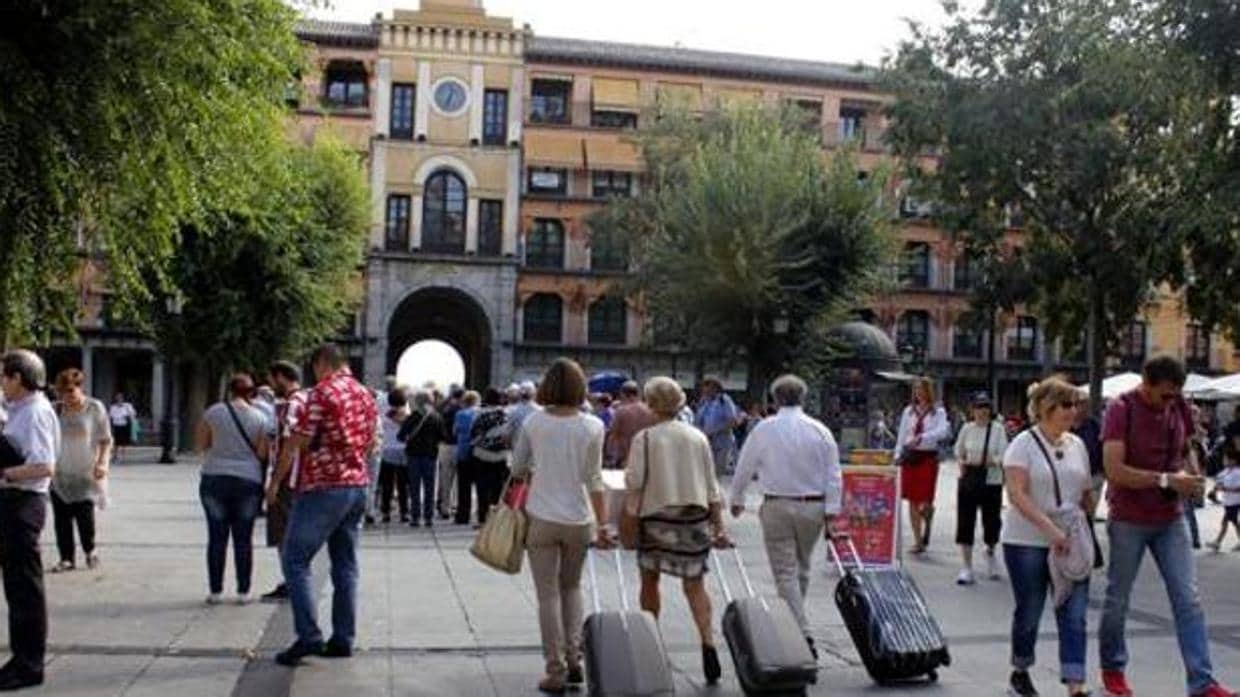 Imagen de turistas con sus maletas por la plaza de Zocodover de Toledo