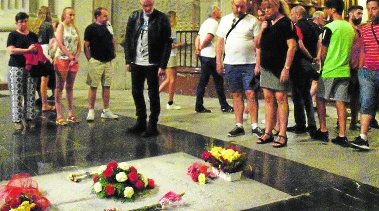 Los turistas contemplan la tumba de Franco, entre fuertes medidas de seguridad, en la basílica del Valle