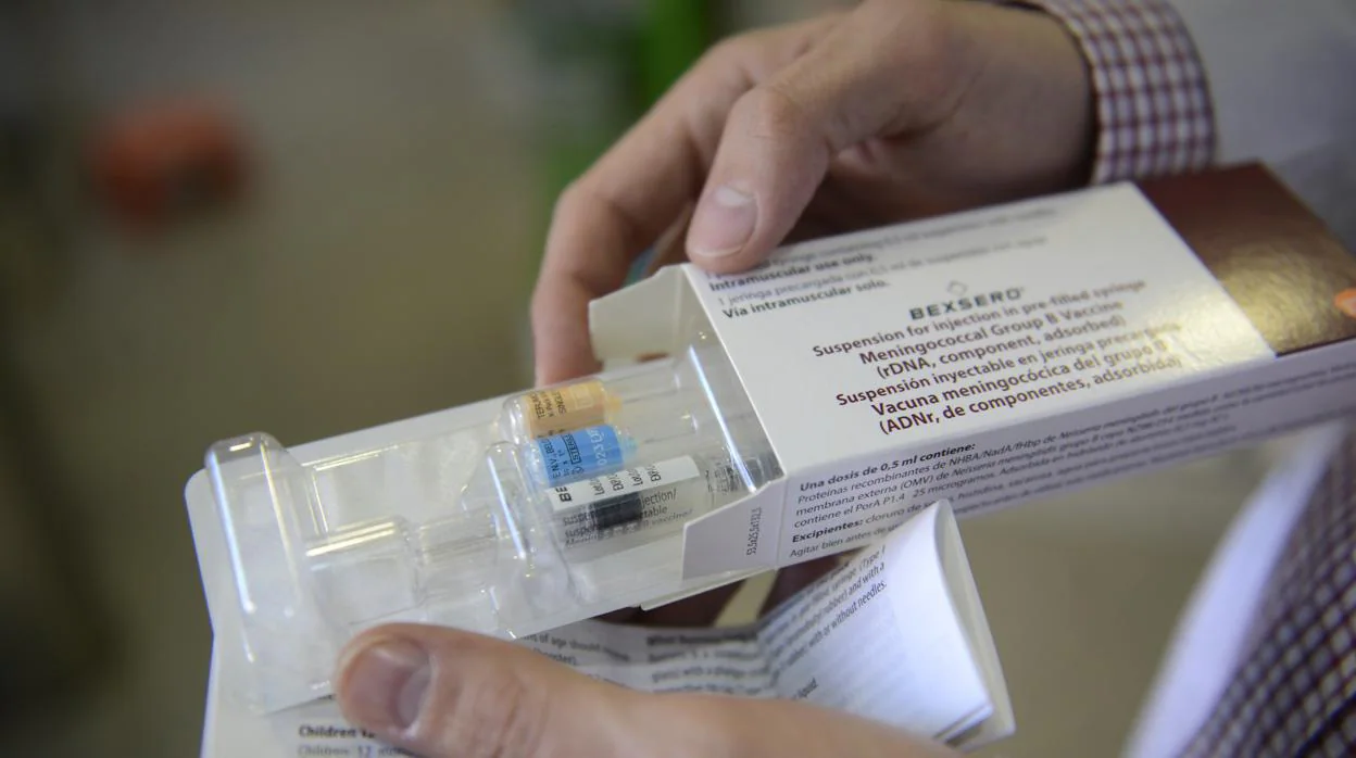 Un médico muestra una vacuna contra la meningitis B