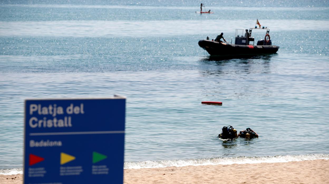 Imagen de los operativos de la Guardia Civil analizando la situación del artefacto encontrado en una playa de Badalona (Barcelona)