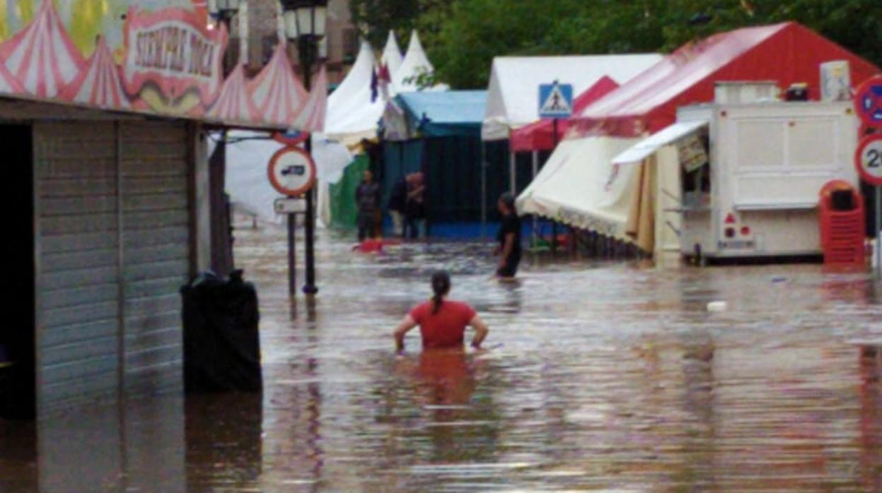 Una mujer camina por la zona inundada donde estaban las atracciones de feria