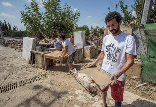 Un hombre muestra una carpa muerta en Molina de Segura (Murcia)