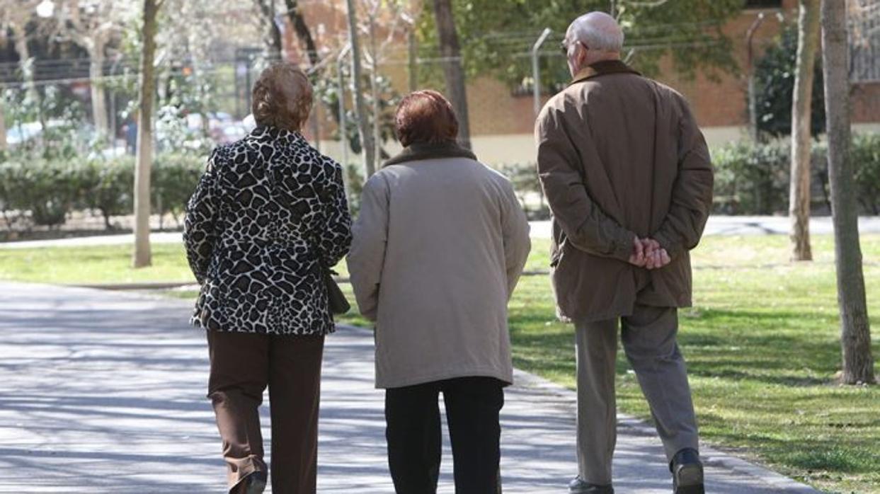 Imagen de archivo de tres personas de la tercera edad pasean por un parque