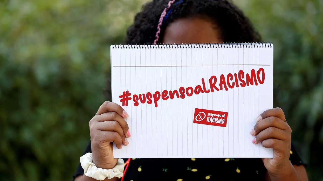 La menor que sufrió acoso escolar posa con el lema que han lanzado sus padres contra el racismo
