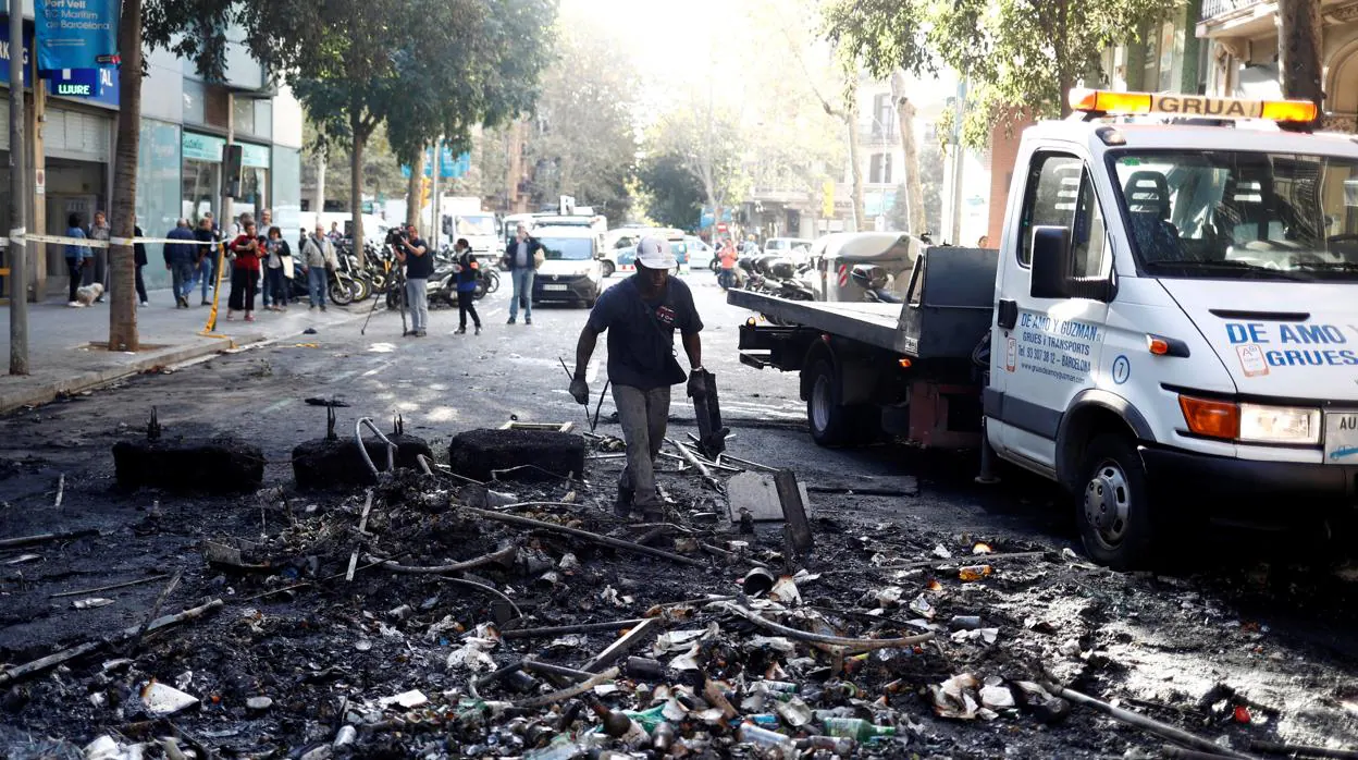 Un trabajador limpia los escombros en Barcelona tras los disturbios de la semana pasada
