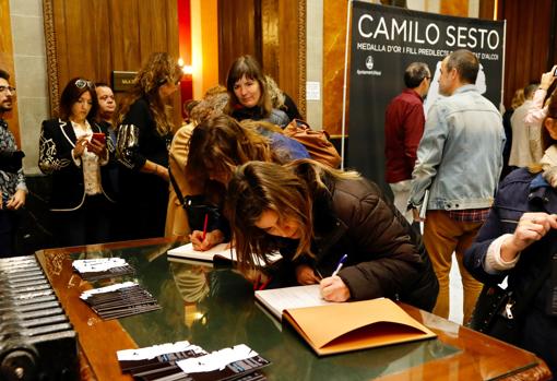 Las admiradoras del cantante más madrugadoras firmandi sus dedicatorias en el libro de recuerdo del homenaje