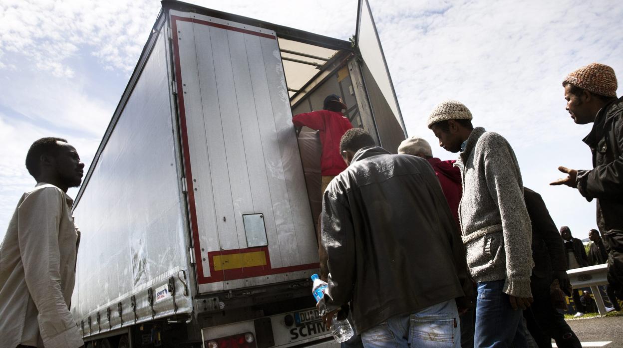 Inmigrantes suben a un camión en dirección al Reino Unido en Calais, en 2015