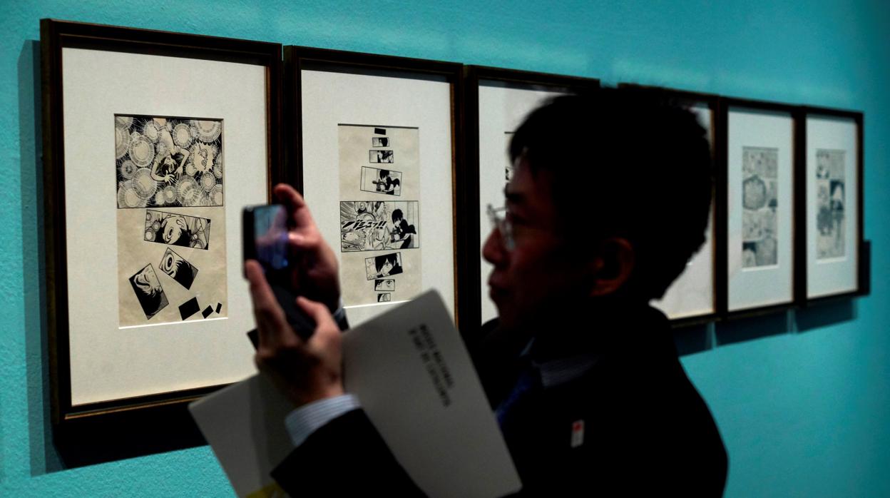 Un visitante fotografía originales de Tezuka en el MNAC