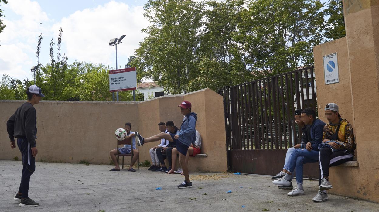 Varios jóvenes juegan en la entrada del centro de Hortaleza