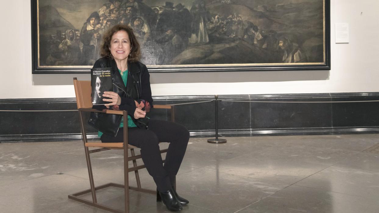 Berna González Harbour posa con su novela, con «La romería de San Isidro», de Goya, al fondo