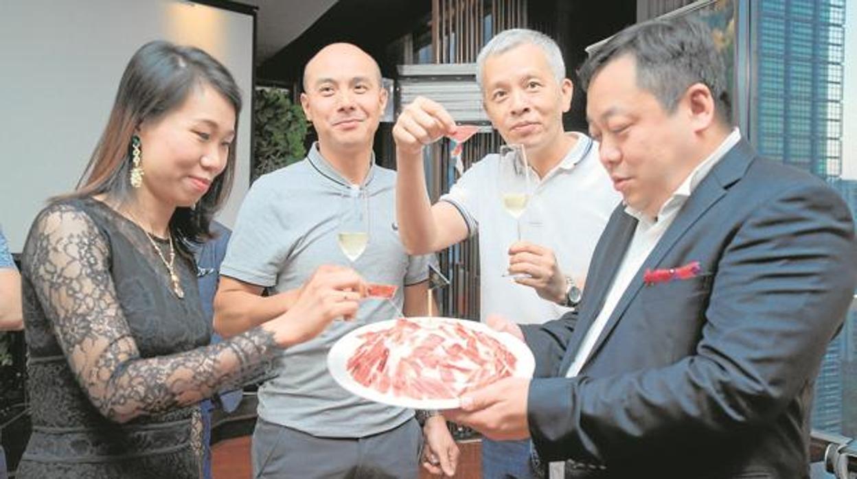 Clientes chinos degustan jamón ibérico en una cena