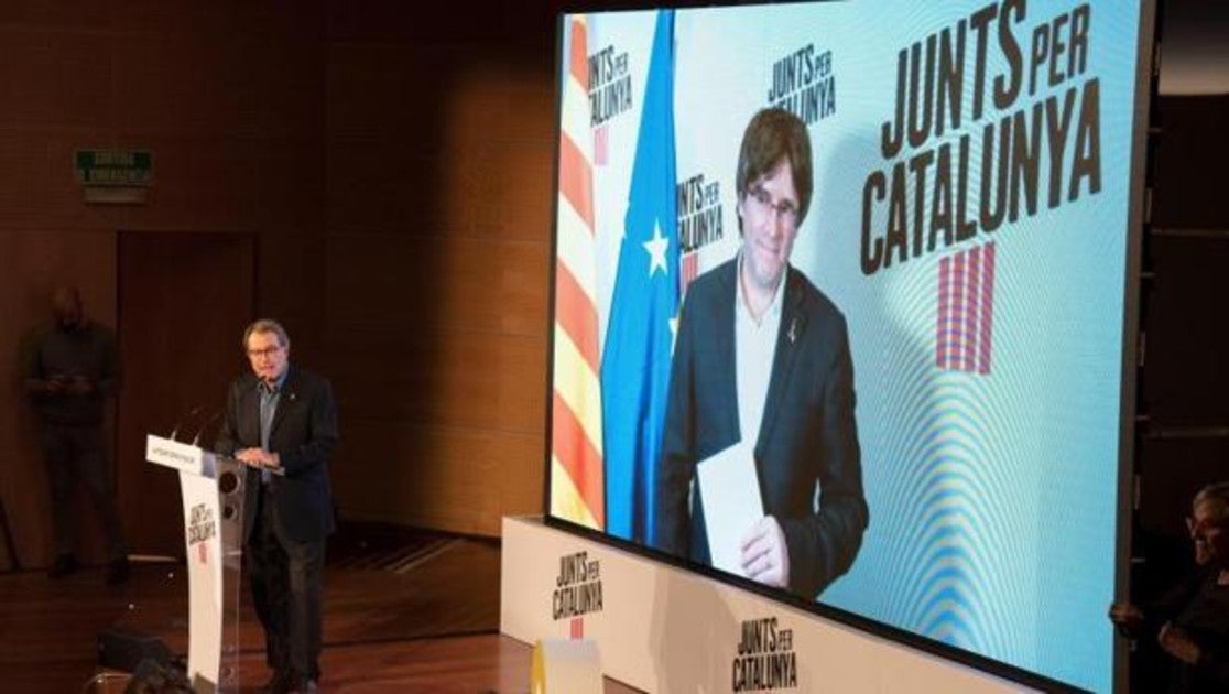 Puigdemont, en una pantalla, en un mitin de JpC en Lérida, con Artur Mas en el atril