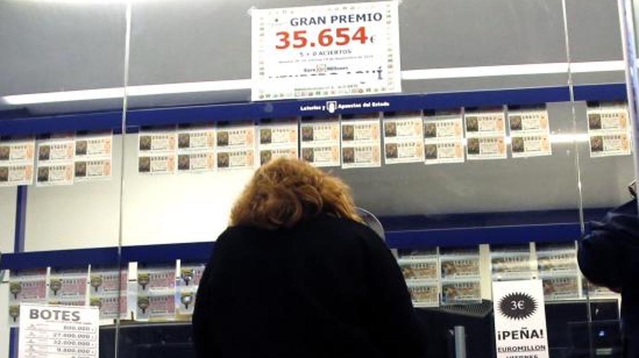 Una mujer compra lotería en una administración alicantina