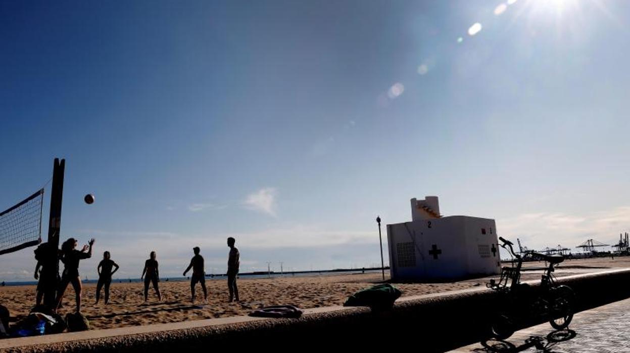 Varias personas disfrutando del buen tiempo este sábado en la playa en Valencia