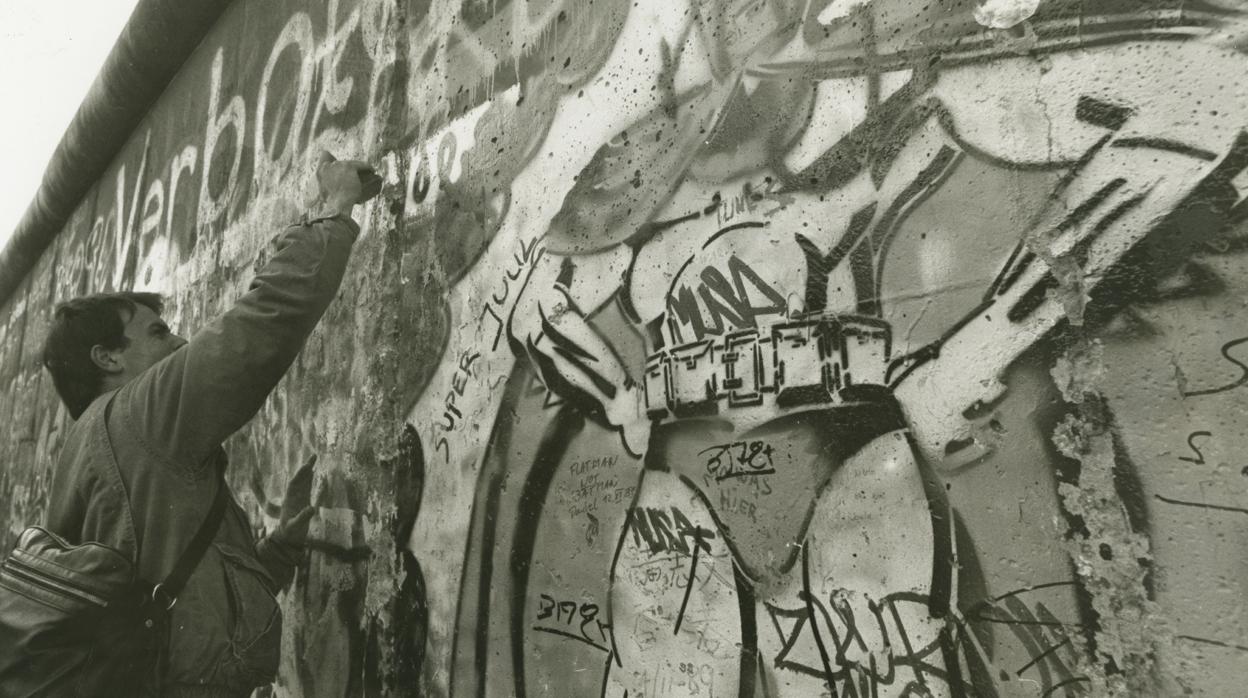 Un alemán celebra la caída del muro de Berlín, en 1989