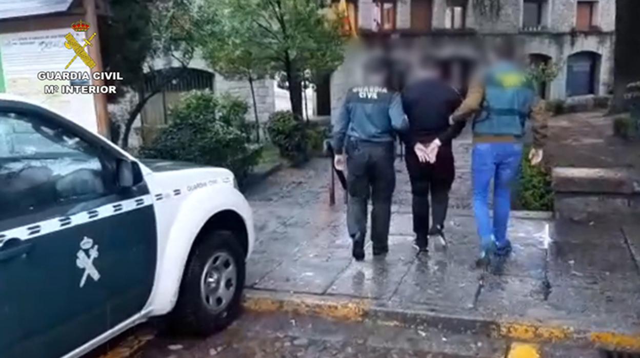 Dos agentes de la Guardia Civil con uno de los detenidos