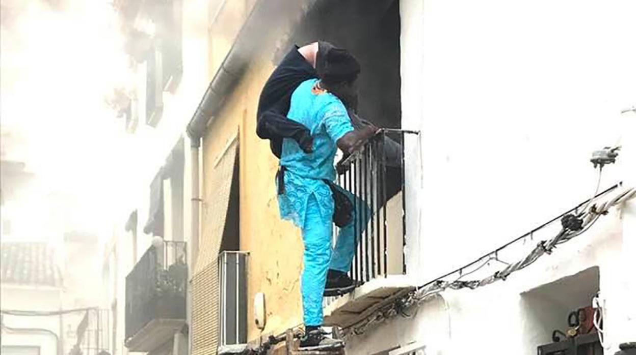 Momento en el que el inmigrante rescataba in extremis al enfermo ya aturdido por el humo y las quemadura en el esófago en el incendio de su casa