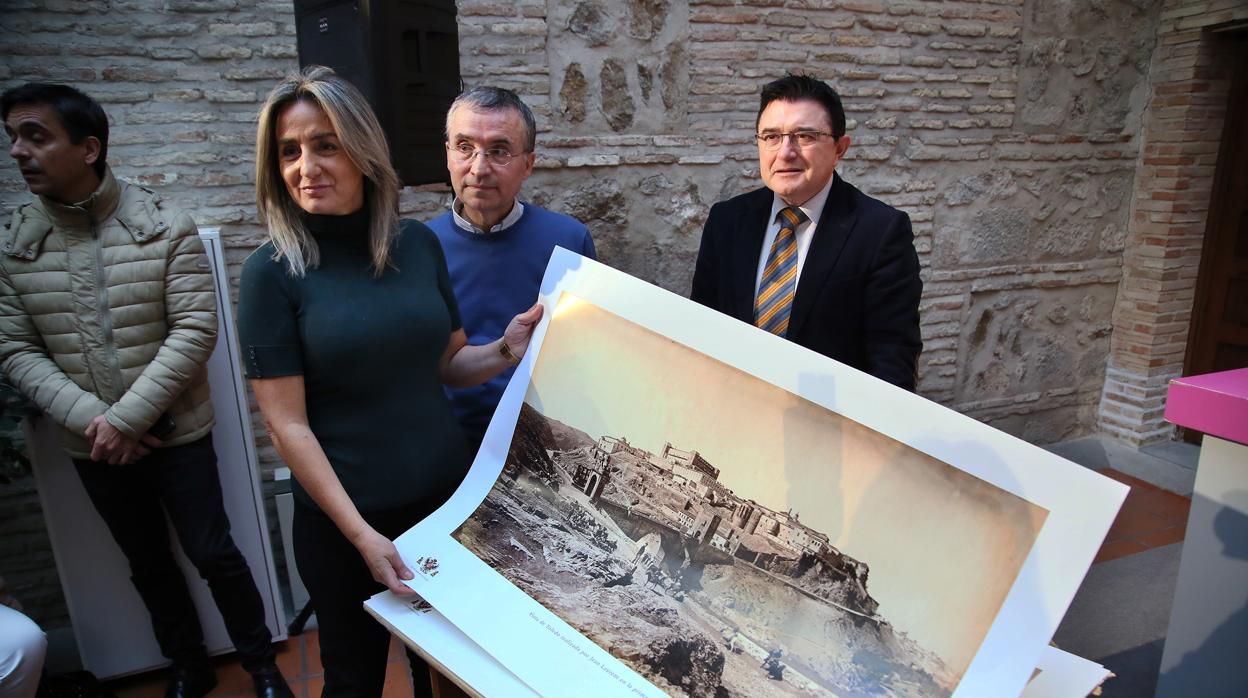 Milagros Tolóncon la lámina de una vista panorámica de Toledo de Laurent en 1865.