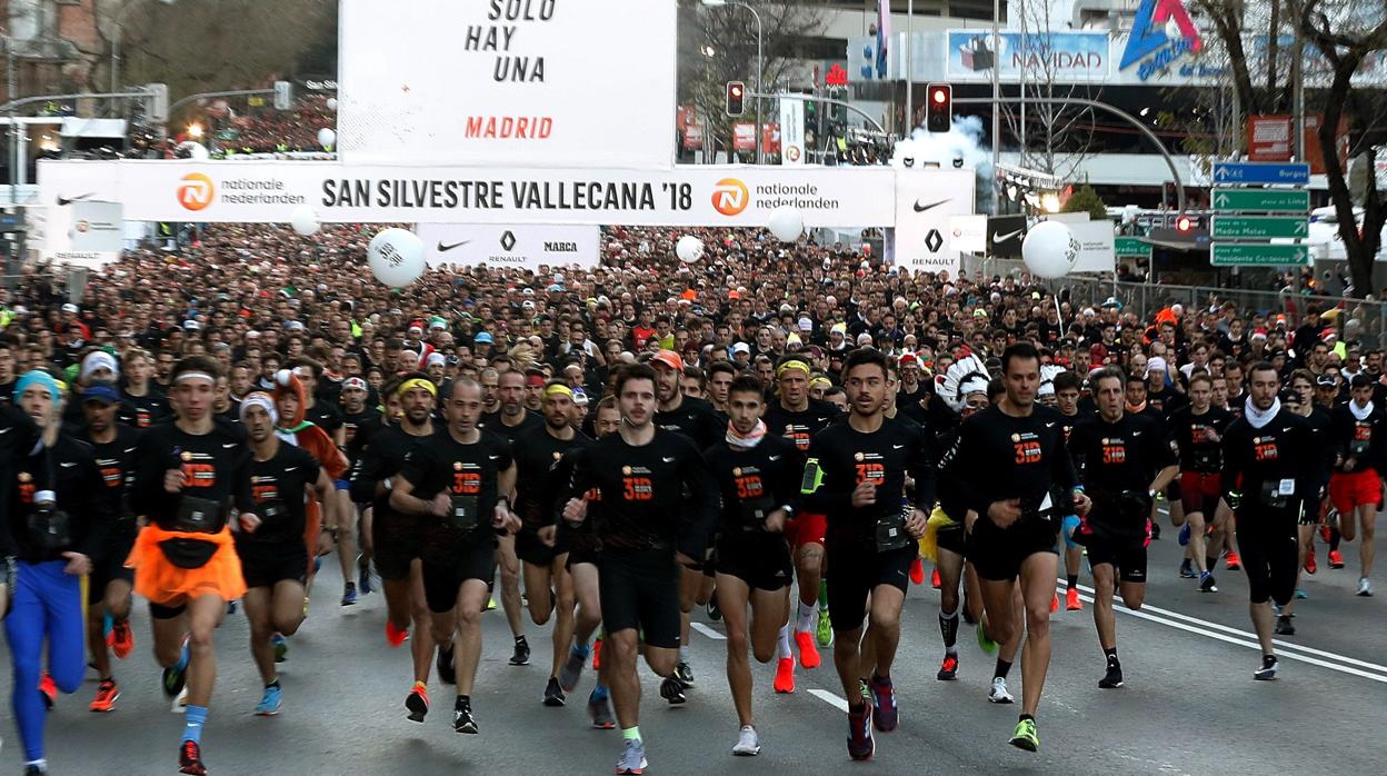 Numerosos corredores tras tomar la salida de la San Silvestre Vallecana Popular