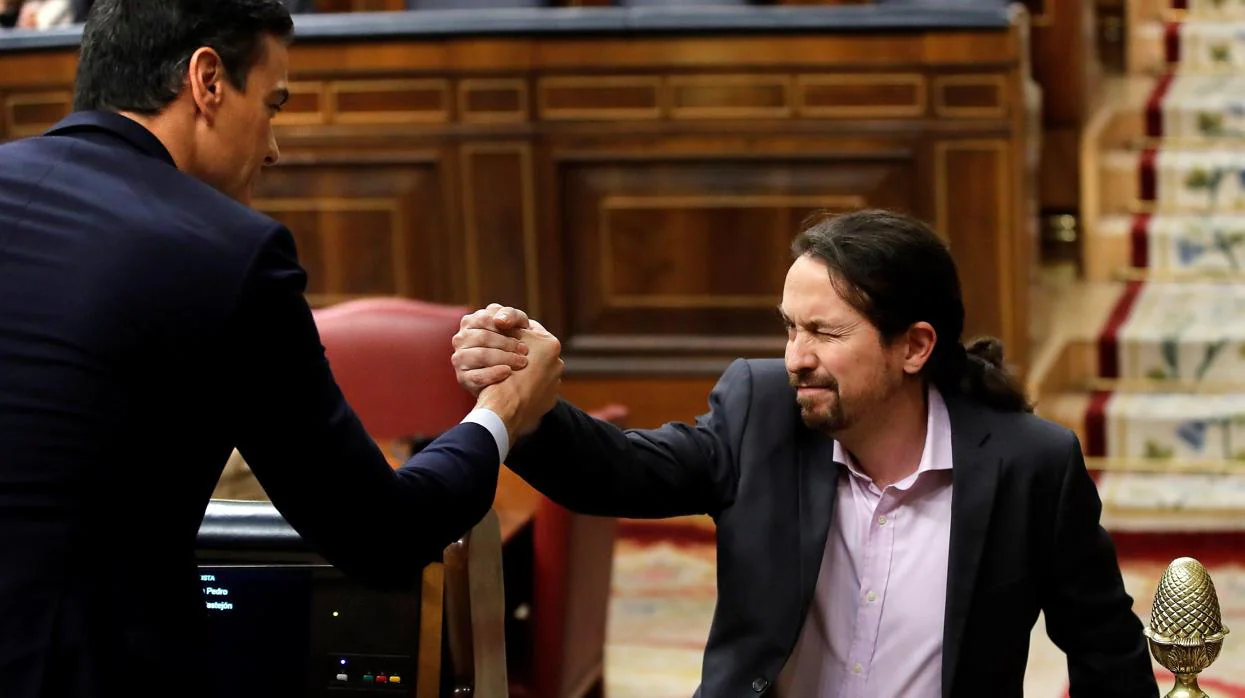 El líder de Unidas Podemos, Pablo Iglesias, saluda a Pedro Sánchez (i), tras su intervención ante el pleno del Congreso de los Diputados en la primera jornada de la sesión de investidura