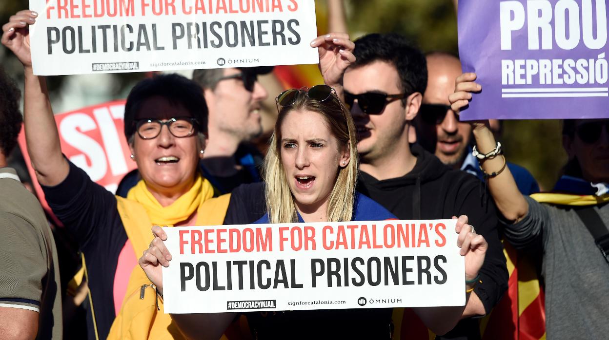 Una manifestante con una pancarta de Òmnium en la que se puede leer «Libertad para los presos políticos catalanes»
