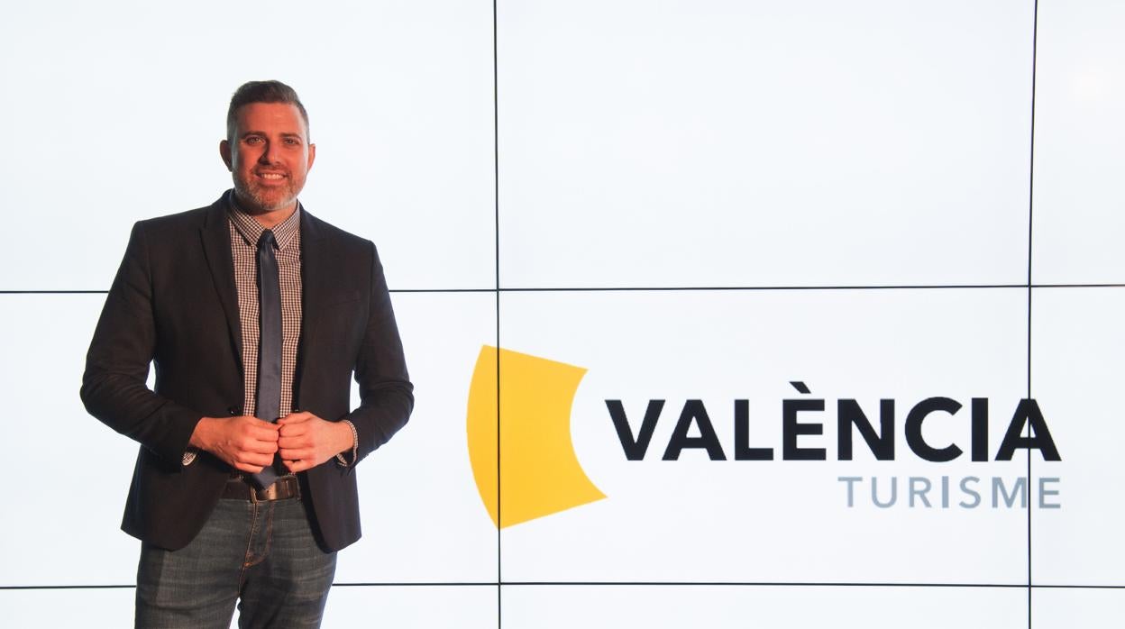 El diputado de Turismo de Valencia, Jordi Mayor, junto a la nueva imagen de València Turisme