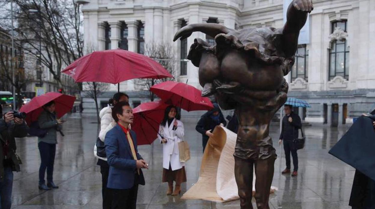 El artista chino Xu Hongfei observa su escultura «El beso» expuesta en la plaza de Cibeles en Madrid