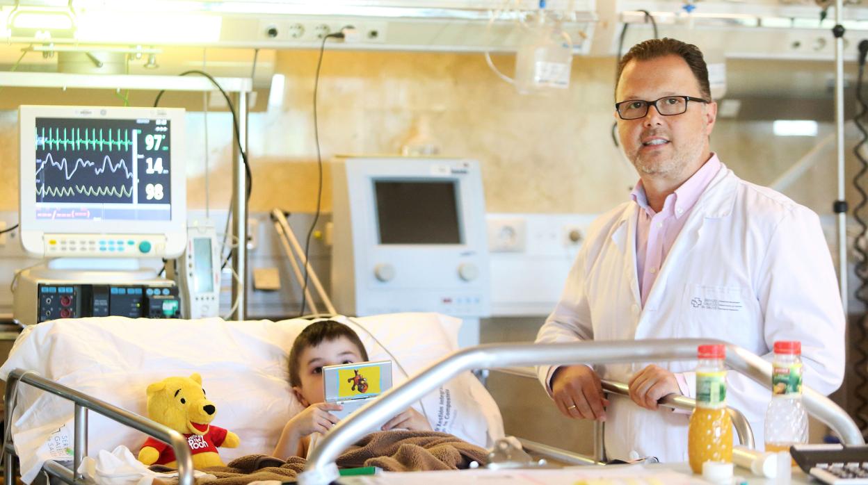 El doctor Federico Martinón, especializado en pediatría, con un niño a pie de cama