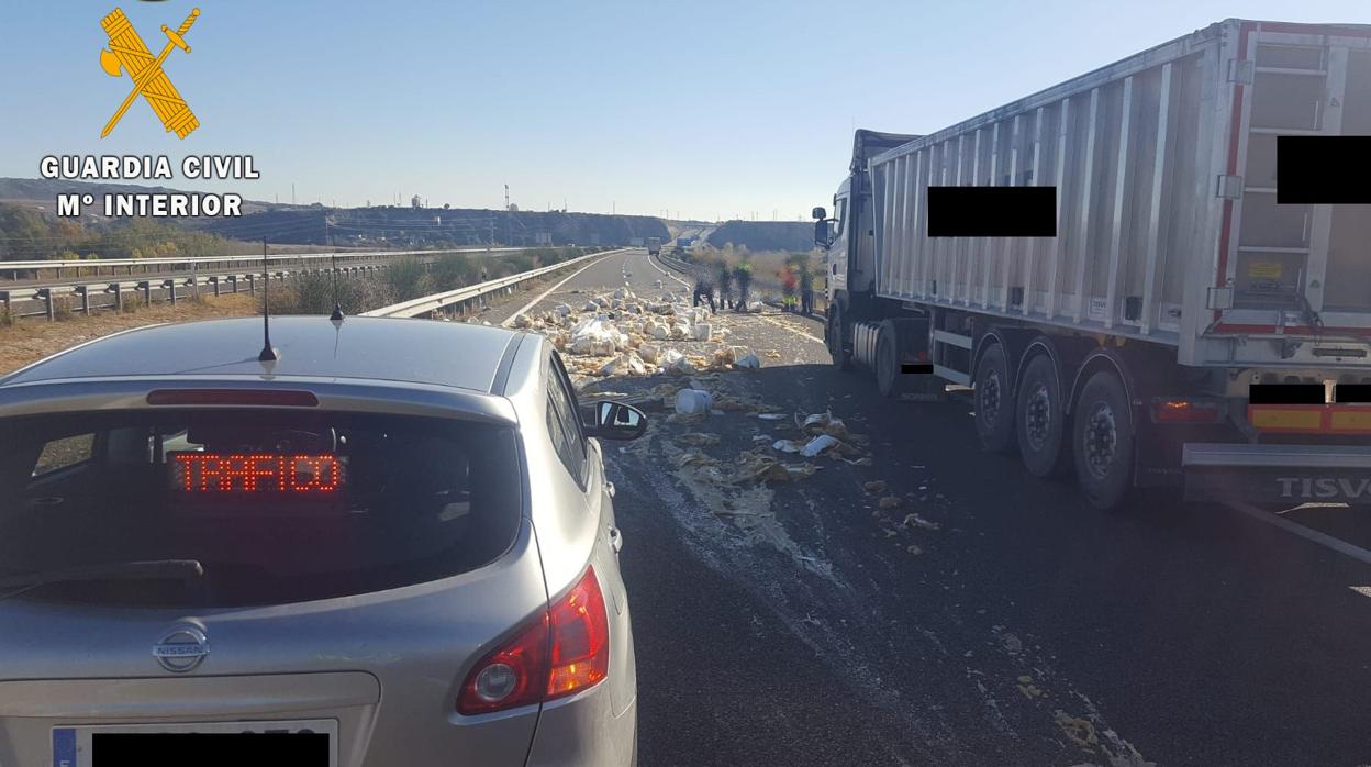 Imagen facilitada por la Guardia Civil en la que aparece el camión y parte de la carga que perdió, esparcida sobre el asfalto de la autovía Lérida-Huesca